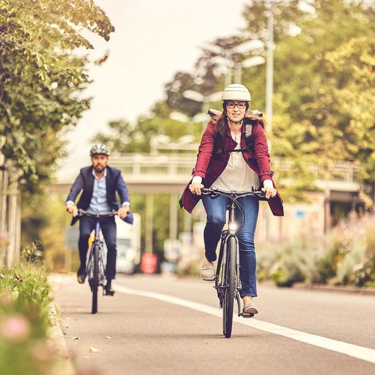 Radfahrerin und Radfahrer auf Fahrradweg