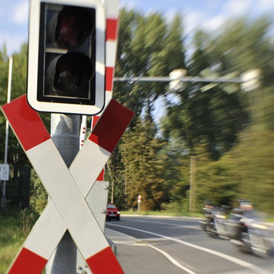 Eisenbahnübergang mit Motorrads, Autos im Hintergrund